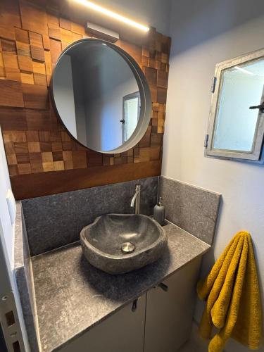 a bathroom with a sink with a large mirror at Autarke Ökovilla in Agios Myronas