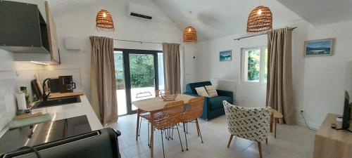 a kitchen and living room with a table and chairs at Le gîte de Coline in La Bridoire