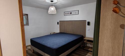 a bedroom with a blue bed in a room at Charmant studio à Castillon du Gard, à deux pas du Pont-du-Gard in Castillon-du-Gard