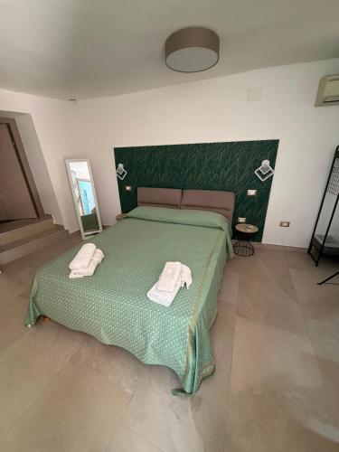 a bedroom with a green bed with towels on it at B&B "Arberia"casa vacanze in San Giorgio Albanese