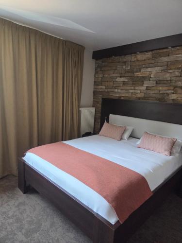 a bedroom with a large bed and a brick wall at Les Portes d'Apcher in Saint-Chély-dʼApcher