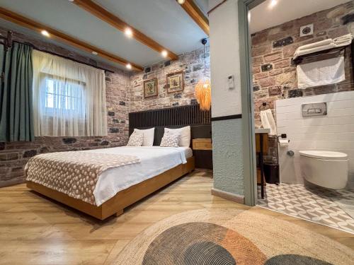 a bedroom with a large bed and a bathroom at Qara Otel in Ayvalık
