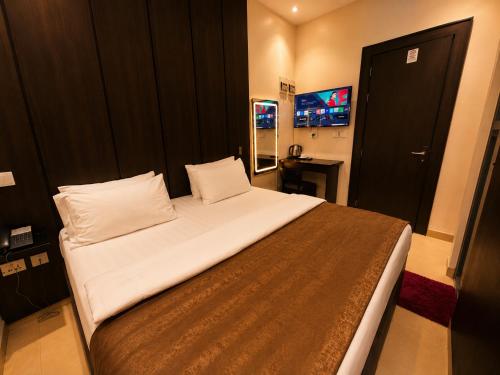 a bedroom with a large bed with white sheets at Westside Beach Resort & Hotel in Mopo Akinlade