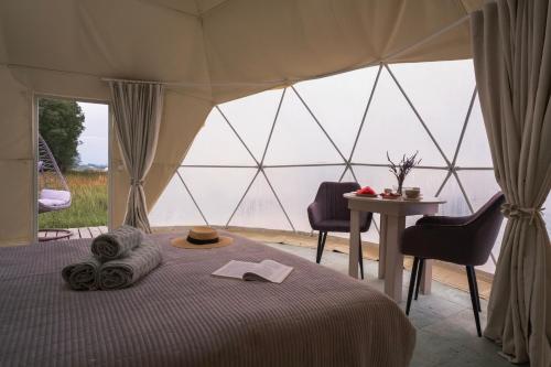 a bed in a tent with a table and chairs at Nomad Space in Bar-Bulak