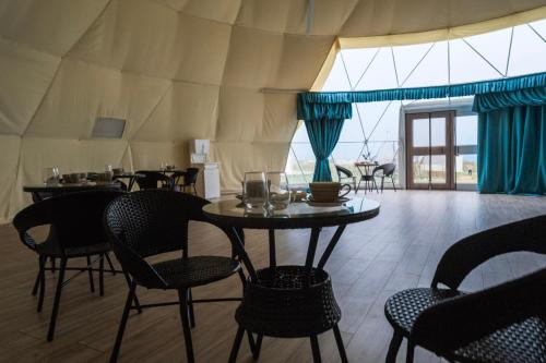a dining room with tables and chairs in a tent at Nomad Space in Bar-Bulak