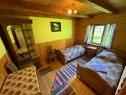 a room with two beds and a chair in a cabin at Shelest Vody in Russkaya Mokraya