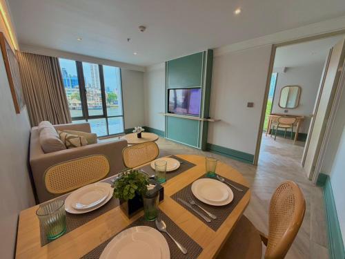 a living room with a table and a couch at The Quarter Chaophraya by UHG - Riverfront Hotel, Walk to ICONSIAM in Bangkok