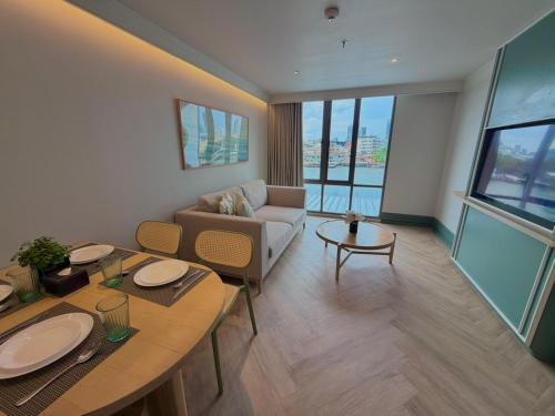 a living room with a couch and a table at The Quarter Chaophraya by UHG - Riverfront Hotel, Walk to ICONSIAM in Bangkok