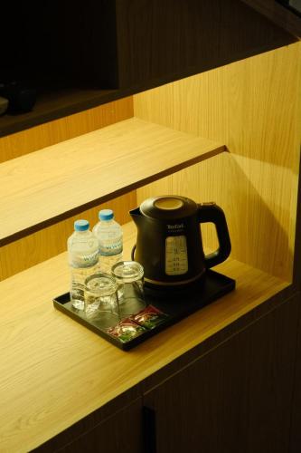 a tea kettle and two bottles of water on a tray at Gaia in Türkistan