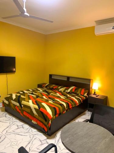 a bedroom with a bed and a tv and a table at Archelux Developments in Bawalishi