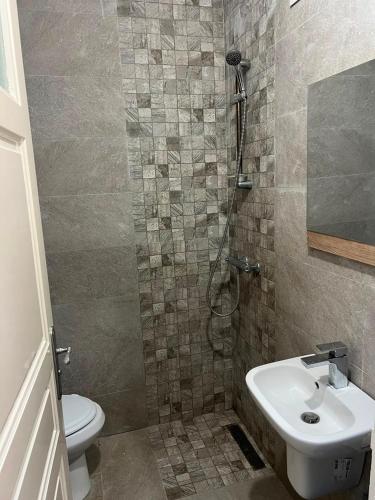 a bathroom with a toilet and a sink and a shower at Dar El corniche in Mahdia