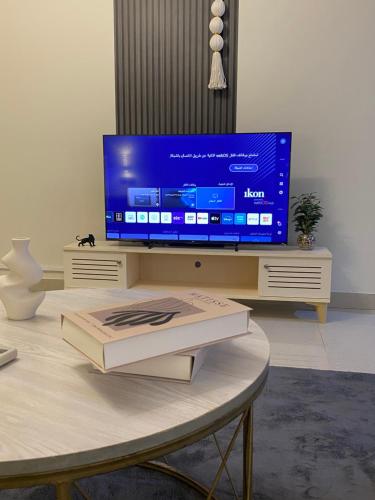 a television sitting on a table in a living room at شقه in Ar Rass