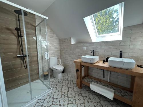 a bathroom with two sinks and a shower and a toilet at La Maison de Gautro in Tréhorenteuc