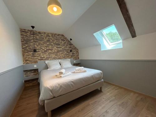 a bedroom with a bed with two towels on it at La Maison de Gautro in Tréhorenteuc