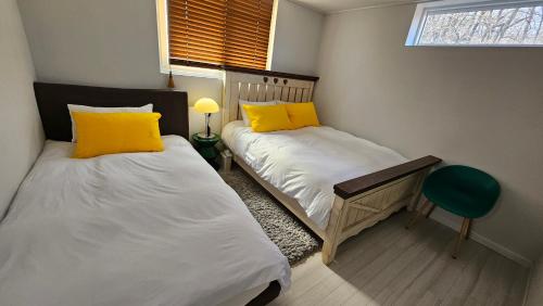 two beds with yellow pillows in a bedroom at 대구 수성구 행복의집 