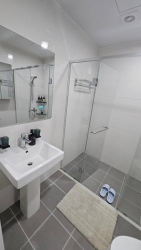 a white bathroom with a sink and a shower at 대구 수성구 행복의집 