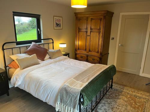 a bedroom with a bed with white sheets and pillows at Glassdrumman Stables in Ballynahinch