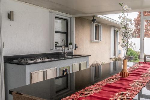 a kitchen with a long counter with a red table cloth at Port St Lucie Poolside Oasis in Port Saint Lucie