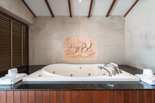 a bath tub in a bathroom with a painting on the wall at Patong 4BR Seaview Villa with Infinity Pool in Patong Beach
