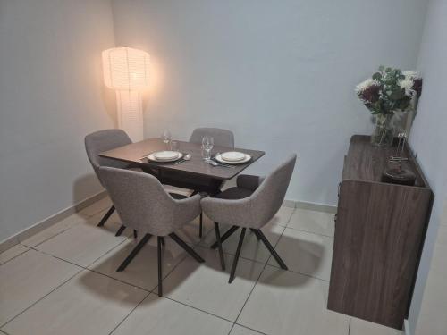 a dining room table with chairs and a table with a lamp at Hcp appartement in Abidjan