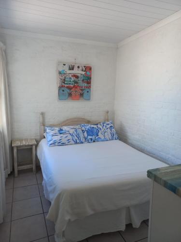 a bedroom with a white bed in a room at Die Waenhuis in Arniston