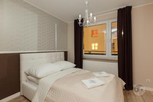 ビャウィストクにあるApartment Royal IIのベッドルーム(白いベッド1台、窓付)