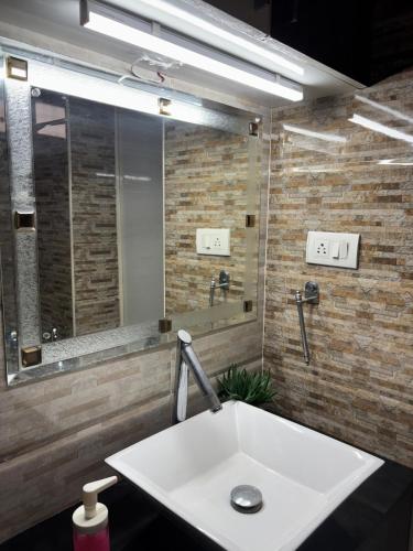 a bathroom with a sink and a large mirror at Luxurious Duplex Villa in Hyderabad