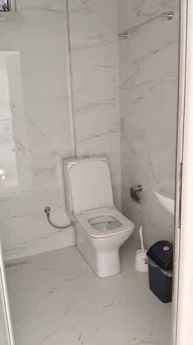 a white bathroom with a toilet and a sink at Alket Rooms for rent in Sarandë