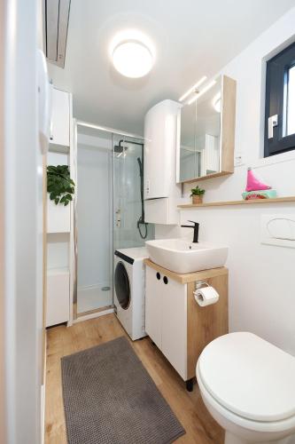 a bathroom with a toilet sink and a washing machine at Pearl Infinity Luxury Floating House in Novigrad Istria