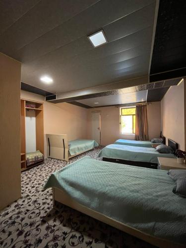 a large room with three beds and a window at Gostevoy dom Dovul in Chimgan