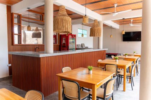 a restaurant with wooden tables and chairs and a counter at Horizonte del Mar Hotel Boutique in Santa Marta