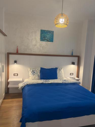 a bedroom with a blue bed and a chandelier at Lili room in Focşani