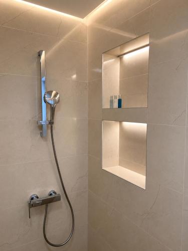 a bathroom with a shower with a mirror and a sink at Apartman Šarić in Neum