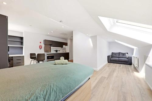 a bedroom with a large bed and a kitchen at Modern Studio in Central Leeds in Leeds