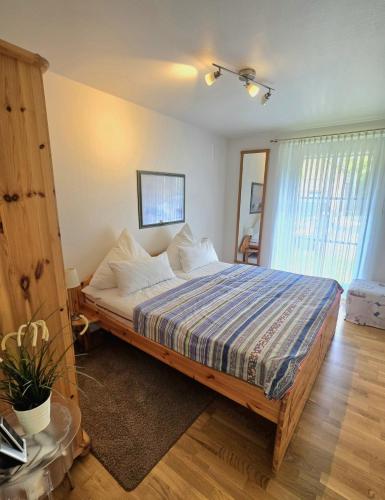 a bedroom with a bed with a blue and white comforter at Köhler-Glowienka, Ute App Nr 3 in Schönberger Strand