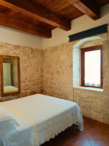 a bedroom with a bed and two windows at Casa Rurale Pietra Bianca in Roccamorice
