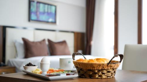 a table with a basket of fruit and a plate of food at EnkayaHotel in Nicosia
