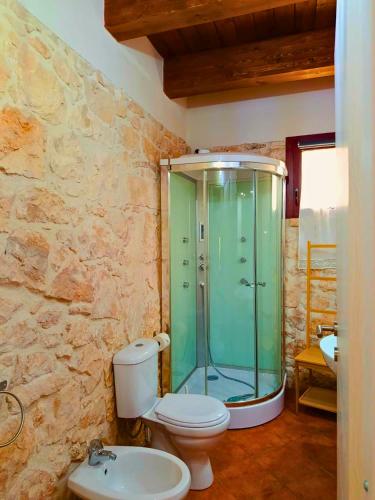 a bathroom with a toilet and a glass shower at Casa Rurale Pietra Bianca in Roccamorice