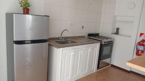 a kitchen with a refrigerator and a sink and a stove at Oro y Miel II en pleno centro de Chascomús in Chascomús
