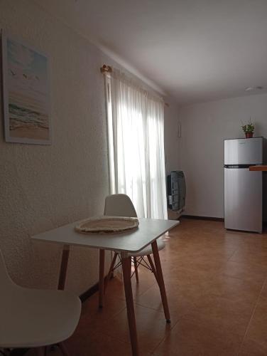 a room with a table and chairs and a refrigerator at Oro y Miel II en pleno centro de Chascomús in Chascomús