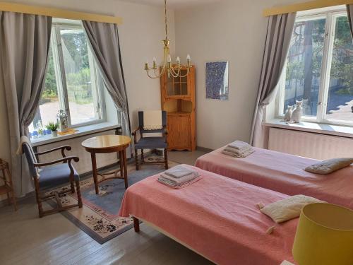 a bedroom with two beds and a table and chairs at Knipnäs Rosengarden in Dragsvik