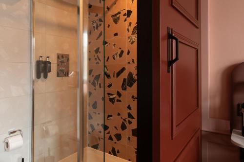 a bathroom with a shower with a glass door at The Address Wren in Glasgow