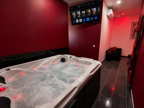a large bath tub in a red bathroom at Eaux Spa Rive Droite in Rouen
