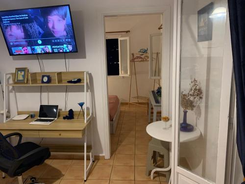 a room with a desk and a tv on the wall at Aegean Overlook Studios in Parikia