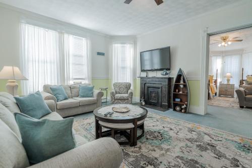 a living room with a couch and a tv at Victorian Inn Bed And Breakfast in Marblehead
