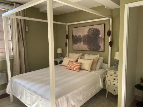 a bedroom with a white canopy bed with pillows at À Plus, Lectoure in Lectoure