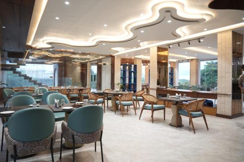 a restaurant with tables and chairs and a large ceiling at Mayur baag resort in Sāgar