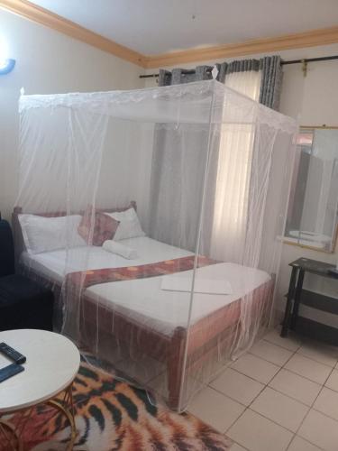 two beds covered in plastic in a room at Silent breeze home in Mombasa