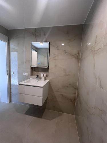 a bathroom with a white sink and a mirror at Ferienwohnung Casa Panorama in Beuren