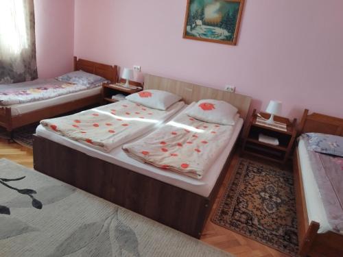two twin beds in a room with two tables at Casa Hirta in Ocna Şugatag